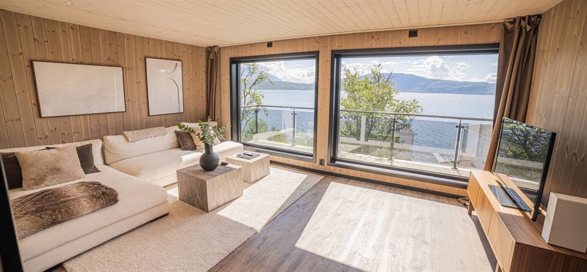 Stue med hvid sofa og panoramavinduer