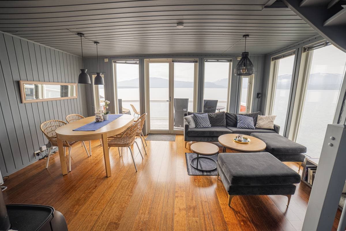 Stue med spisebord og fjordudsigt