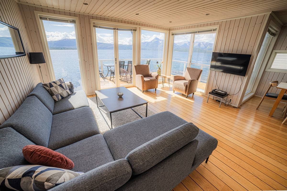 Stue med grå sofa og fjordudsigt