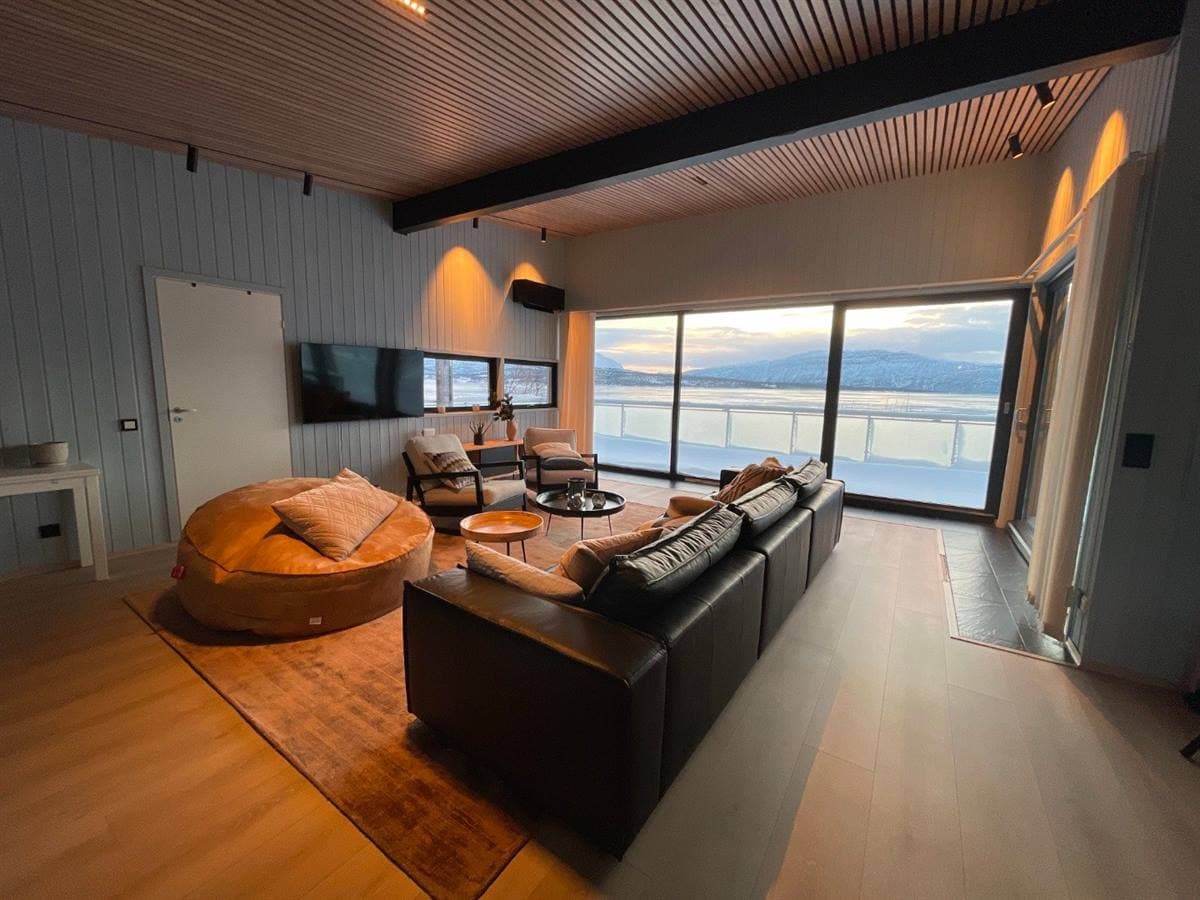 Stue med lædersofa og panoramavindue
