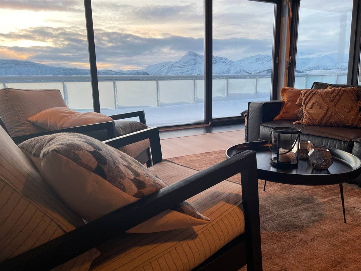 Sofagruppe i stuen med udsigt over den snedækkede fjord