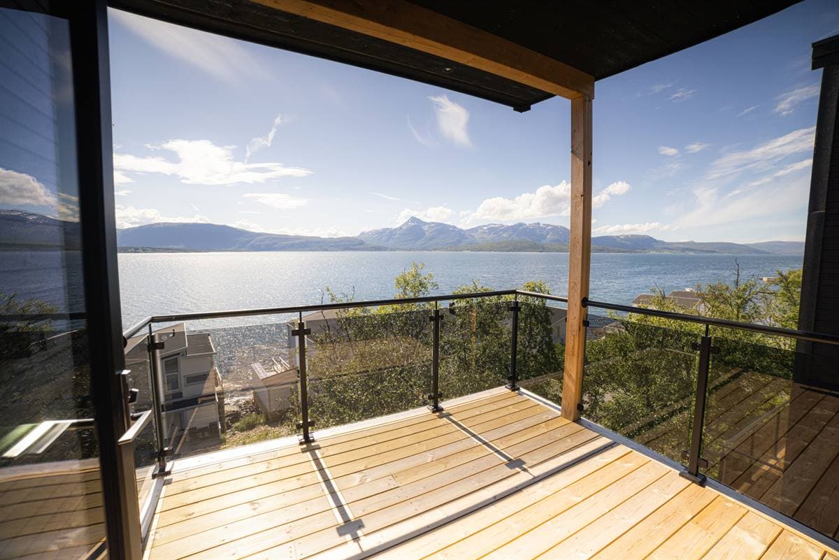 Altan med glasrækværk over fjorden