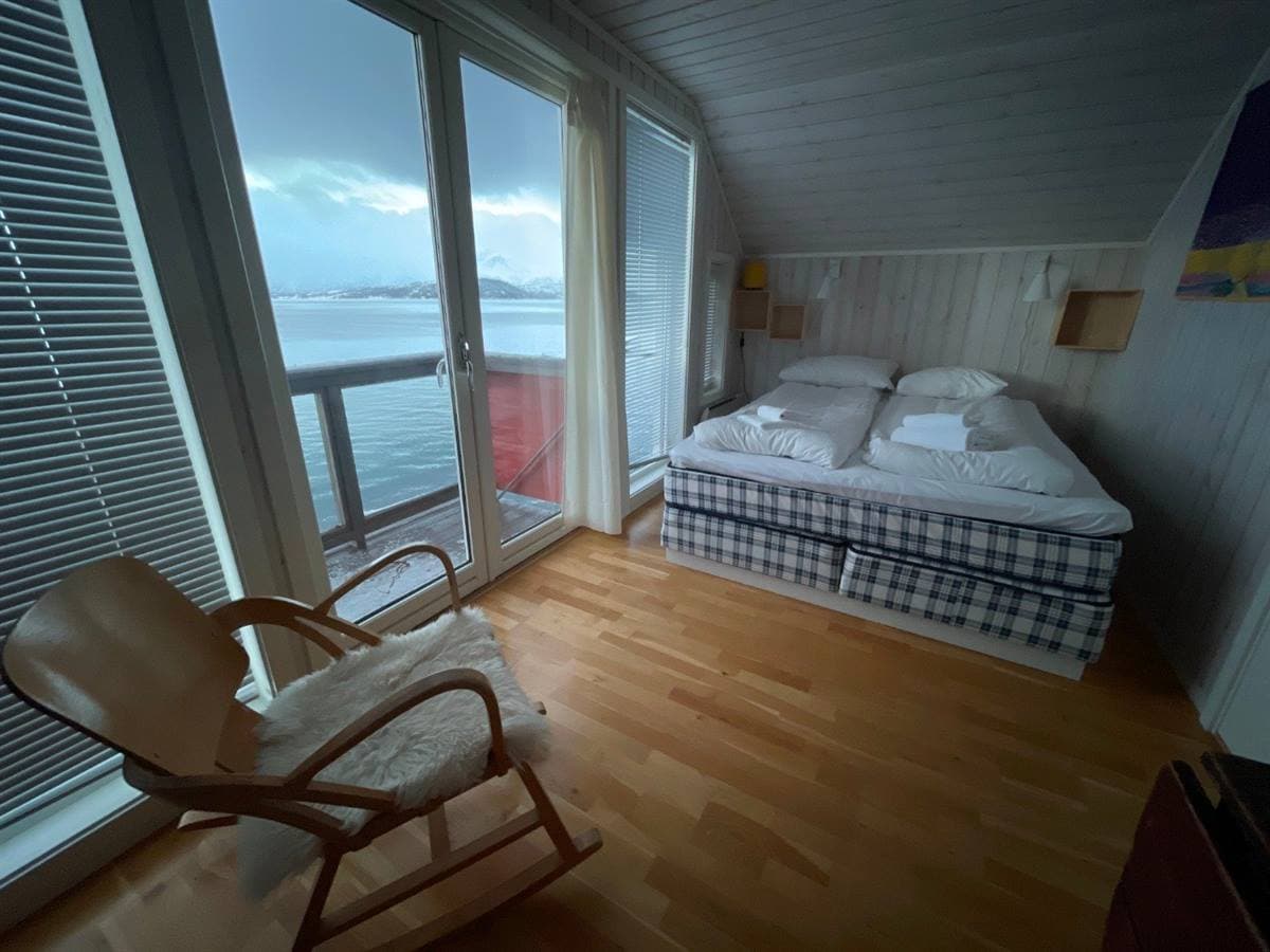 Soveværelse med dobbeltseng, vindue ud mod fjorden og gyngestol